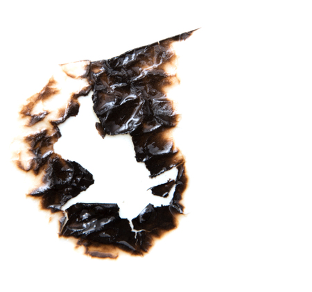 burned hole on a white paper backgroundの写真素材