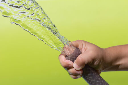 spray water from a hose child's handの写真素材