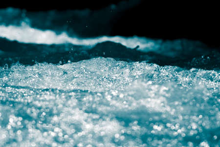 blue bubbling water from beneath the wavesの写真素材