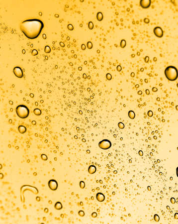 golden water drops on glassの写真素材