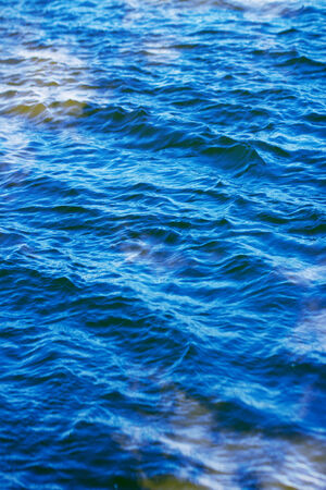 sky with clouds reflected on the water surface with waves