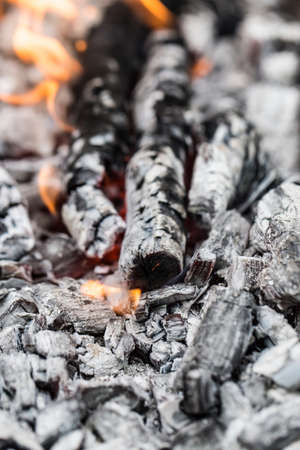 Campfire with burning firewood on foreground closeupの写真素材