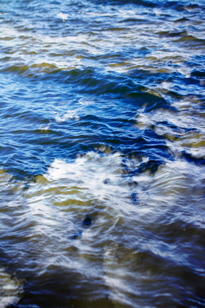 sky with clouds reflected on the water surface with waves