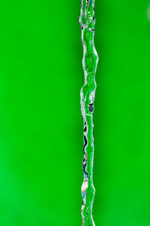 a jet of water on a green backgroundの写真素材