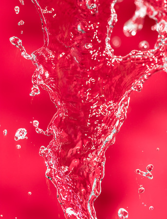 spray water on the red backgroundの写真素材