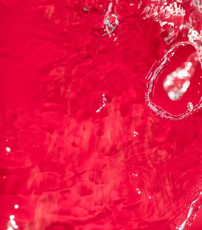 spray water on the red backgroundの写真素材