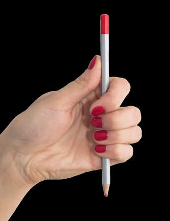 pencil in hand with red nail polish on a black backgroundの写真素材