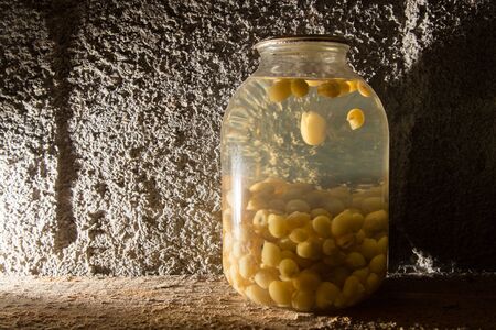 Old bank with grape compote in the basement in the darkの写真素材