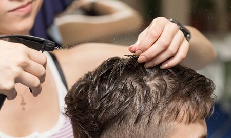 Rear view of man getting a haircut in beauty salonの写真素材