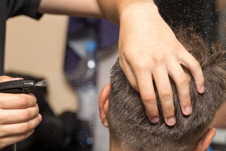 spraying with hair spray in beauty salonの写真素材