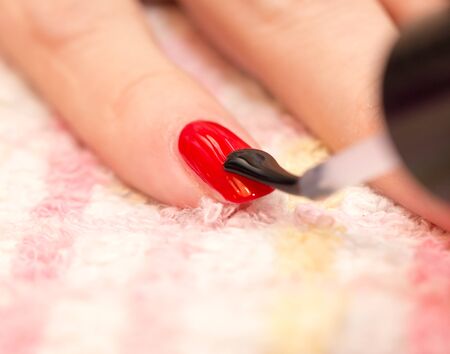 nails painted red nail polish in a beauty salonの写真素材