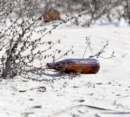 Glass bottles in the sand on nature. trashの写真素材