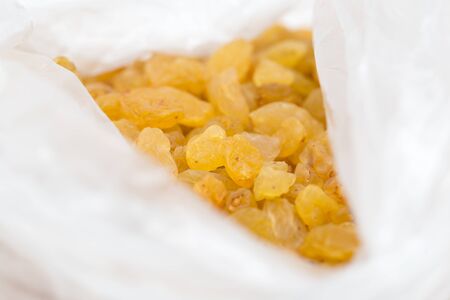 yellow raisins in a plastic bagの写真素材