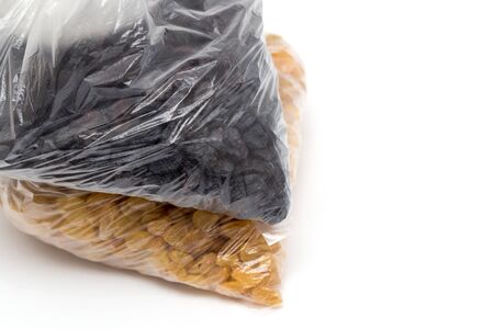 black and yellow raisins in a plastic bagの写真素材