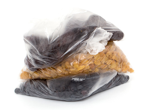 black and yellow raisins in a plastic bagの写真素材