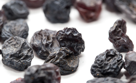 Black raisins on a white background. macroの写真素材