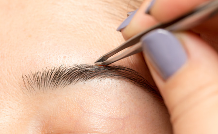 Grooming the eyebrows in a beauty salonの写真素材