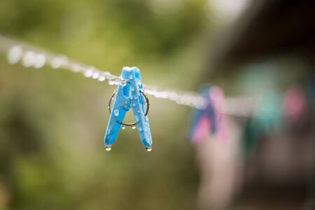 Clothes peg with water drops after rain in the morning.の写真素材