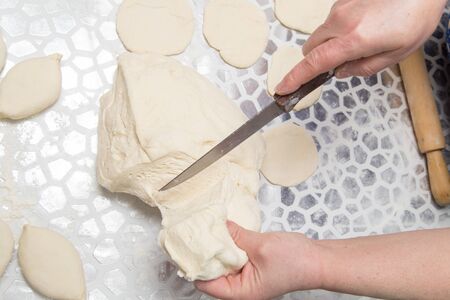 cutting the dough with a knife in the kitchen