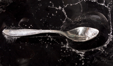 Spoon in a spray of waterの写真素材
