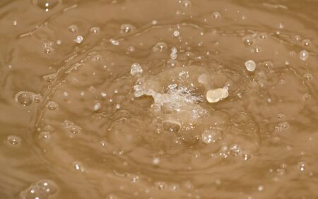 Drops of water falling into the dirty water