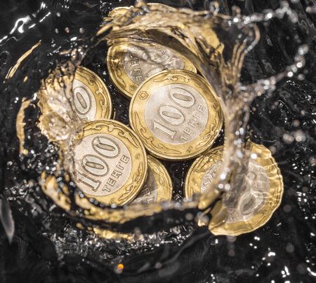 coins in water splashes on a black background