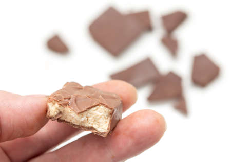 chocolate in his hand on a white background