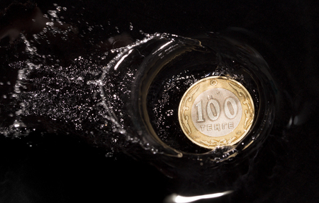 coins in water splashes on a black backgroundの写真素材