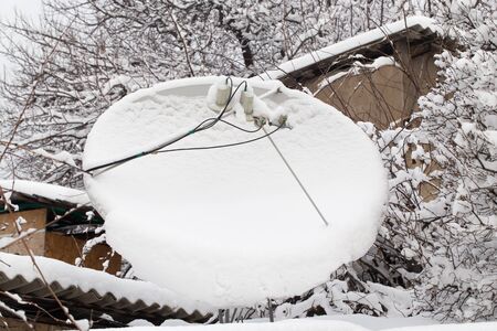 snow on the satellite dish in the winterの写真素材