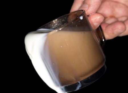 milk in a glass on a black backgroundの写真素材