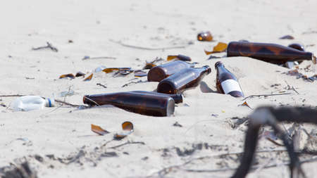 Glass bottles in the sand on nature. trashの写真素材