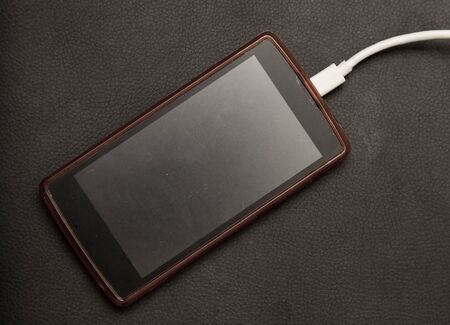 phone charging on a black backgroundの写真素材