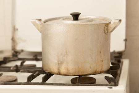 aluminum pan on old dirty gas stoveの写真素材