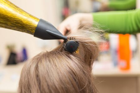 Hairdresser dries the hair dryer blond  hairの写真素材