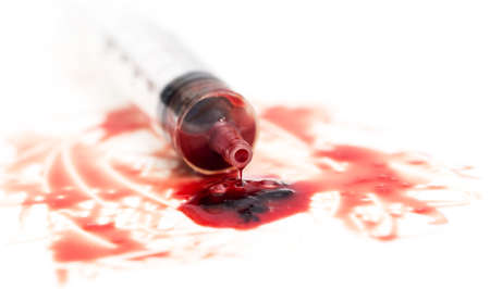 syringe and red blood on white background