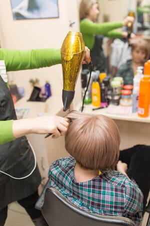Hairdresser dries the hair dryer blond  hairの写真素材