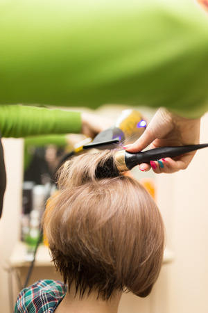 Hairdresser dries the hair dryer blond  hairの写真素材