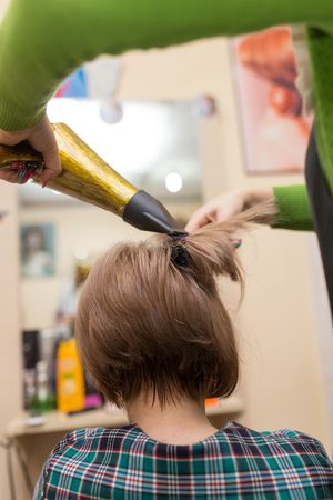 Hairdresser dries the hair dryer blond  hairの写真素材