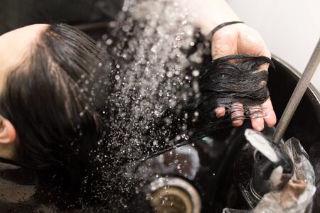Hairstylist washing woman hair. Hairdressing beauty salonの写真素材
