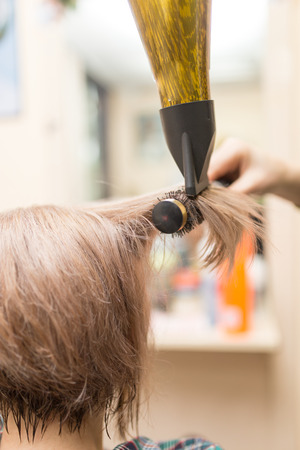 Hairdresser dries the hair dryer blond  hairの写真素材