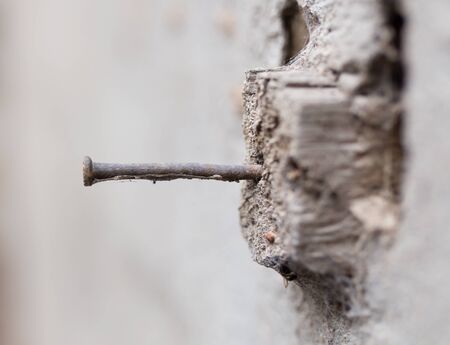 old rusty nail hammered into a piece of wood