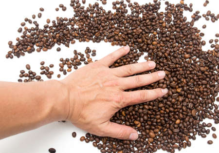hand on coffee beans as backgroundの写真素材