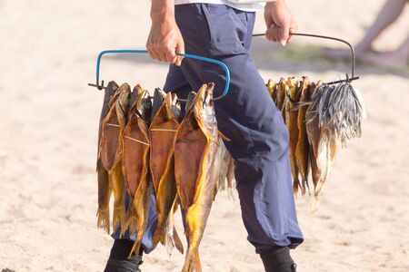 bunch of smoked fish in handの写真素材