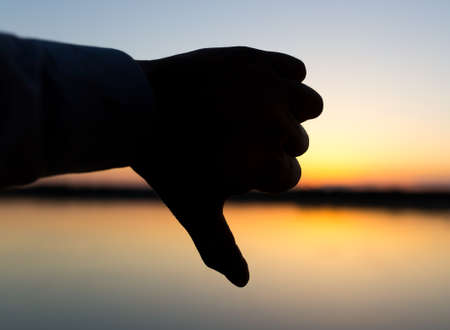 silhouette of the hand on the sunset backgroundの写真素材