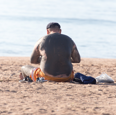 a man in the mud on the beachの写真素材