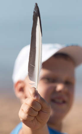 a feather in his hand boyの写真素材