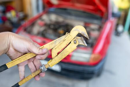 Wrench in hand on the background of cars