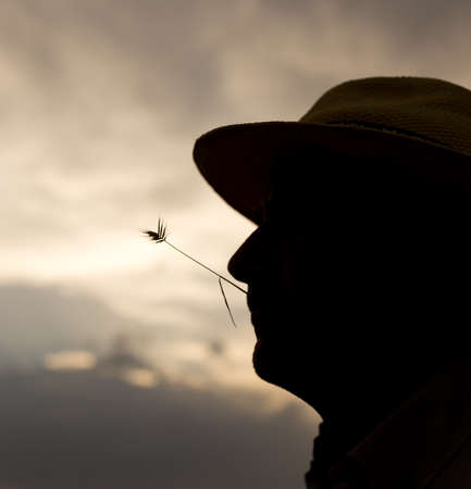 silhouette of a man with a hat on sunset backgroundの写真素材