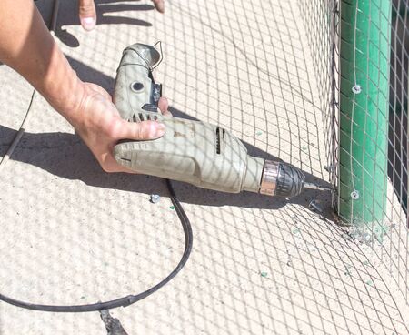 Worker twists the screw into the metalの写真素材