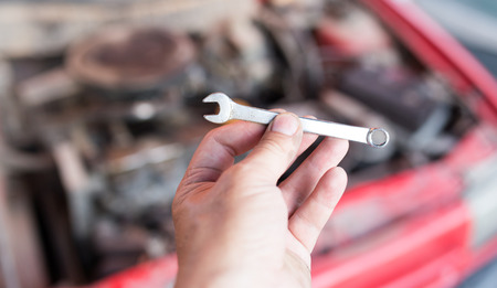 Wrench in hand on the background of carsの写真素材